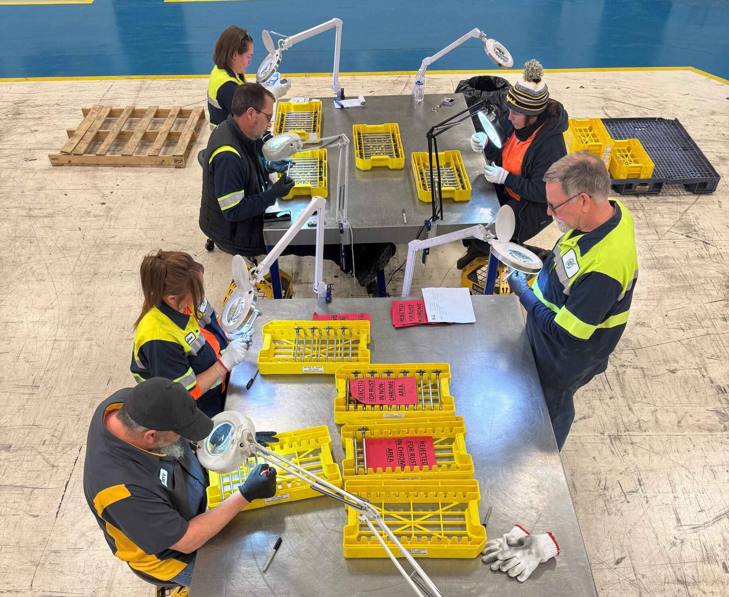 a team of industrial inspectors are inspecting different components gathered around a table, showcasing teamwork and efficienc