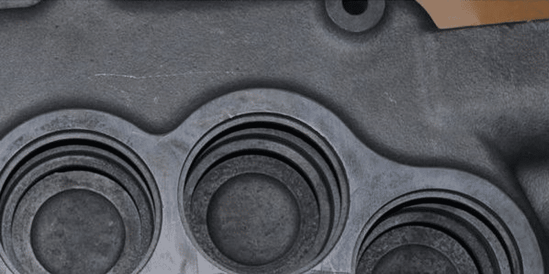 Derusting - post-de-rusting clean, close-up view of a metallic component featuring four circular holes on it's surface.
