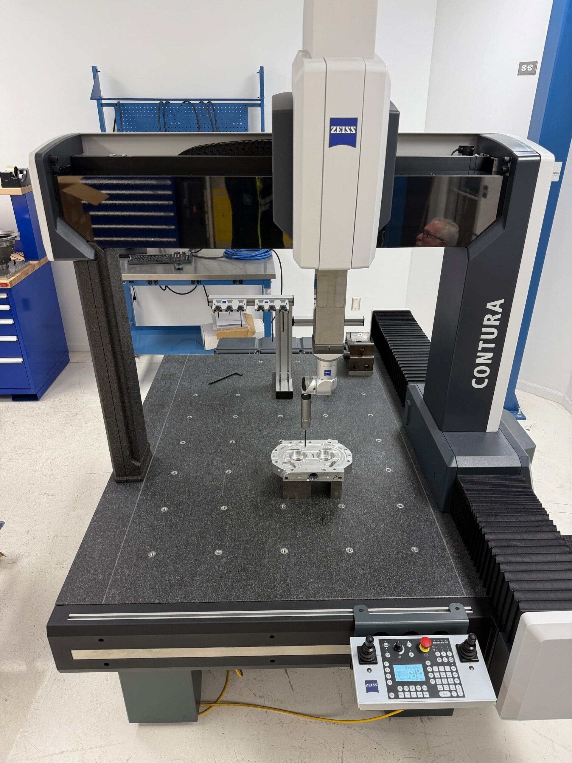 A zeiss CMM machine in operation, fabricating a precise component for manufacturing purposes.